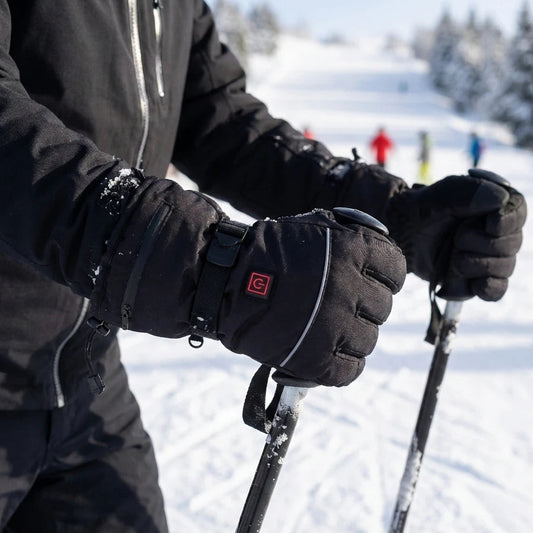 Zwarte verwarmde wintersport-handschoenen met ingebouwd bedieningspaneeltje op de bovenkant van de hand en verstelbare polsband.